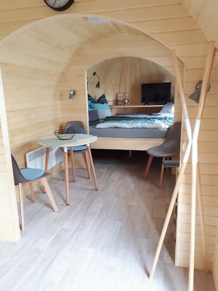 Innenraum mit Essplatz und Schlafbereich in Holzoptik